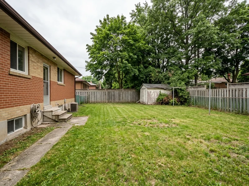 Before: wide empty North York backyard with an old shed
